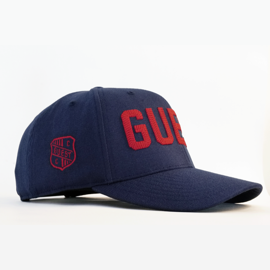 Side profile of navy blue Country Club GUEST golf hat with red embroidered lettering and red crest logo