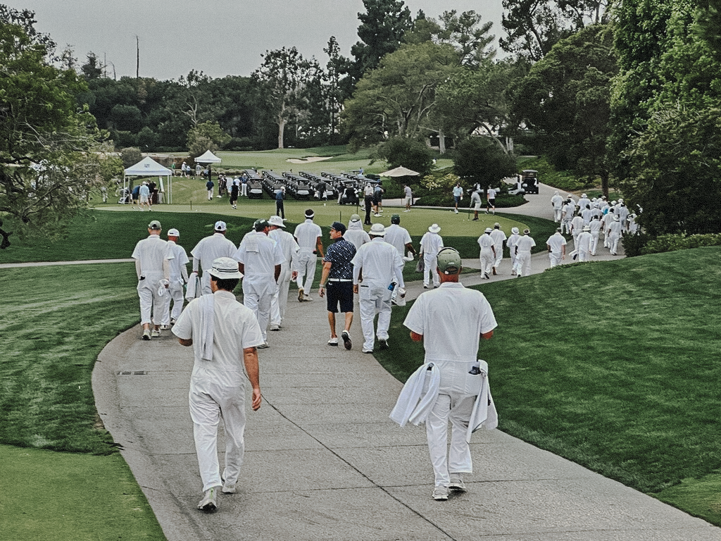 Lone guest walking among the caddies at a country club golf course.